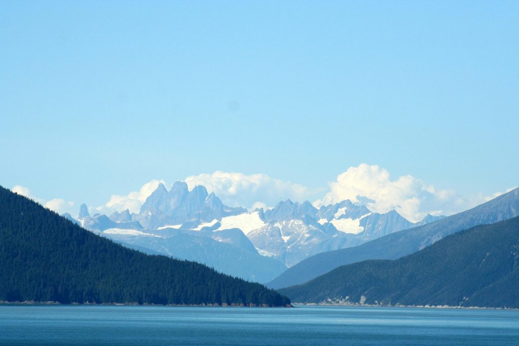 Breathtaking view of Alaska's mountains with clear blue skies and serene waters.