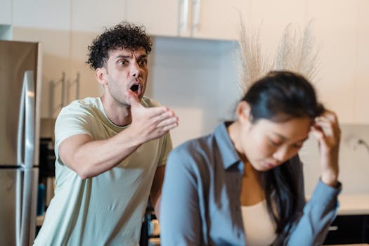 A stressed couple arguing in a modern kitchen, highlighting relationship issues.